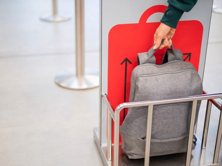Handgepäck-Überprüfung mittels Metallkäfig (baggage sizer) am Check-In-Schalter des Flughafens